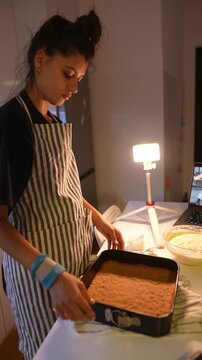 Seasoned female expertly spreads filling across crust evenly