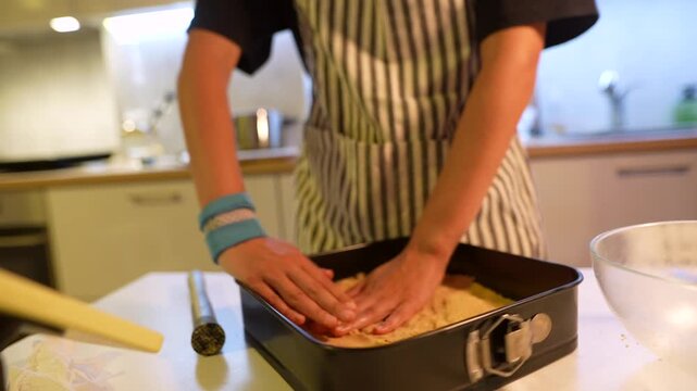 Pressing dough firmly. Applying consistent pressure to form base