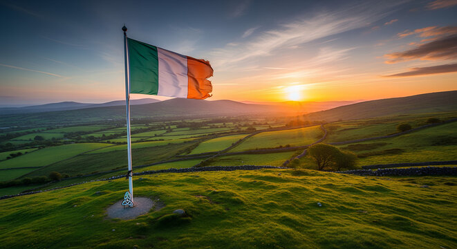 Irish flag waving on a green hill at sunset with scenic landscape