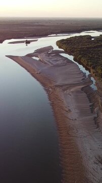High angle aerial view of winding Syr Darya river with sandy banks and forest at sunset, panoramic landscape, Kazakhstan. High quality 4k footage