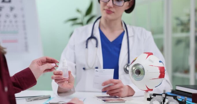 Ophthalmologist gives eyedrops bottle and prescription to woman in clinic. Female doctor consults patient about vision health in hospital slow motion