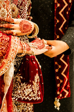Couple holding hands featuring intricate henna designs and traditional bridal wear tradition marriage pakistani feminine