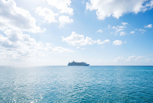Cruise ship at the horizon of calm ocean on a sunny day