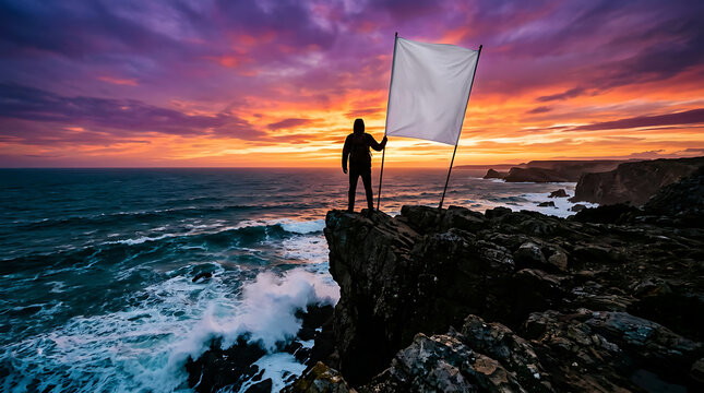 Man holding blank flag on cliff at sunset, ocean waves crashing on rocks