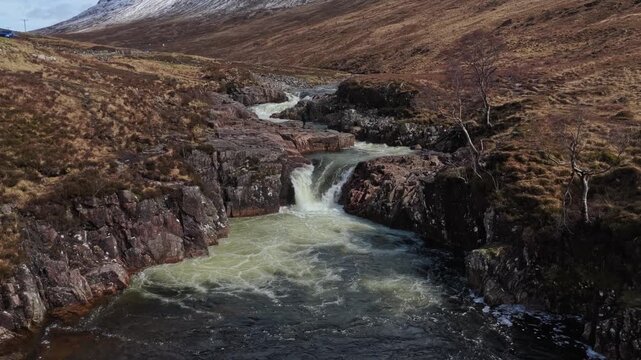 Drone flying backward above the river etive waterfall in glencoe