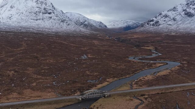 Cars driving over river etive bridge in scottish highlands winter