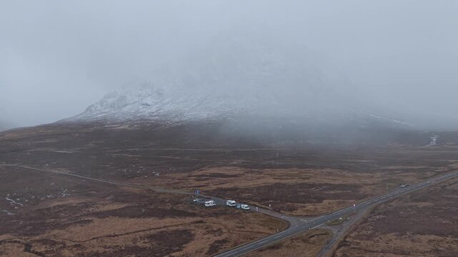 Foggy mountainous landscape with cars and road in glencoe