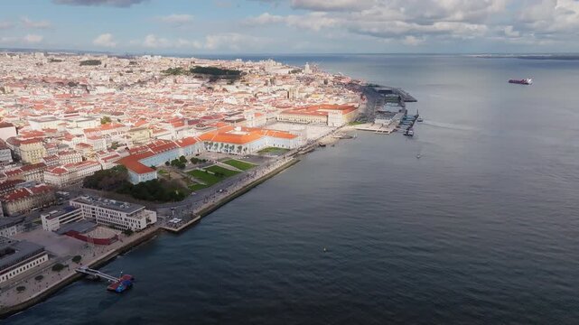 Panoramic drone shot of Lisbon at sunset flying from the sea toward Praca do Comercio near Caldeirinha Dock