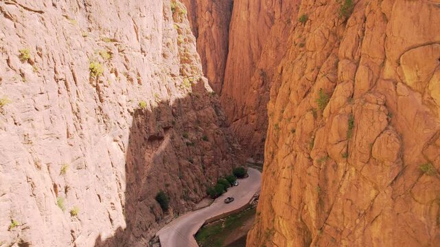 Todra Gorge near Tinghir, Dr&acirc;a Tafilalet, Morocco, featuring massive limestone canyon walls sculpted by the Todgha River within the eastern High Atlas mountain system, drone parallax pullback ascent