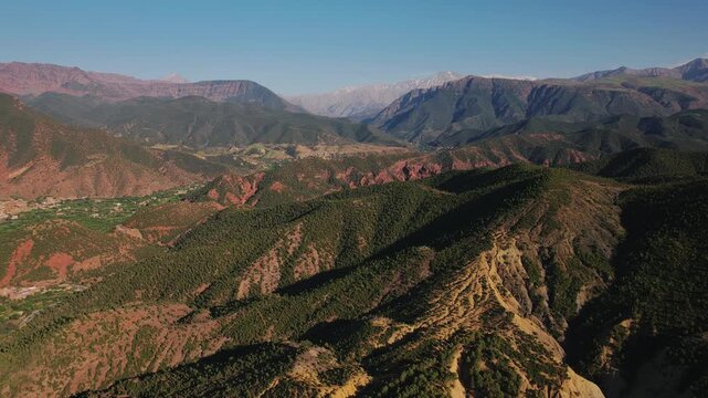 Ourika Valley, Al Haouz Province, Marrakesh Safi, Morocco, featuring eroded sedimentary ridges, juniper woodland and the snow covered Toubkal massif within the High Atlas Mountains, parallax orbit