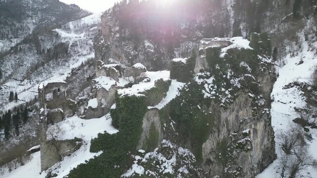 Historical Kustul Monastery ruins surrounded by green forest and winter snow in Trabzon.