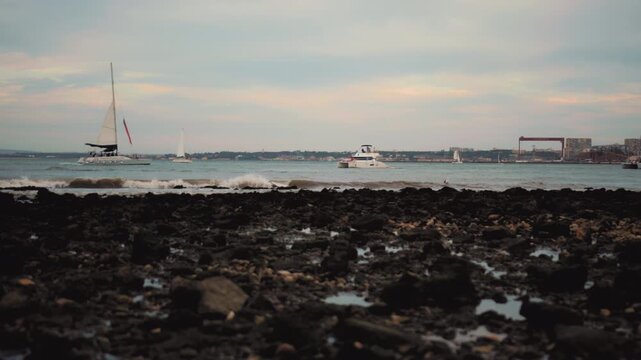 Naval patrol ship navigating the coastal waters of Lisbon bay view from a rocky beach