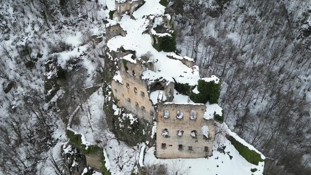 Top down aerial drone shot of ancient Kustul Monastery ruins under the snow in winter.