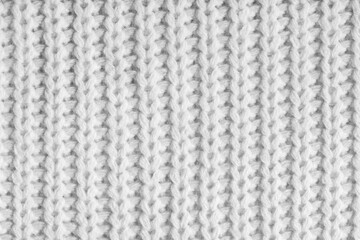 Close up, macro of white knitted fabric texture with visible yarn stitches and soft wool pattern. Cozy textile backdrop, cloth background, fashion wallpaper, handmade or winter clothing concepts © katyamaximenko