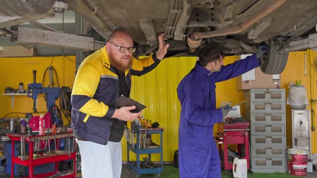 Car maintenance workshop garage instructional session indoor close-up automotive knowledge sharing