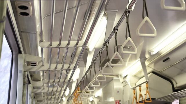電車車内のずらりと並んだ吊り革と網棚を見上げた遠近感のある風景