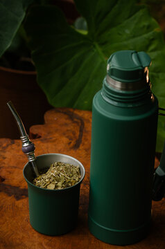 Mate y termo color verde sobre una mesa r&uacute;stica en la naturaleza
