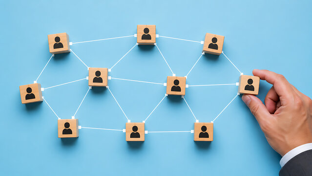 Businessman hand holding wooden block with black people icon connected in a structured network representing corporate team organization structure and human resources