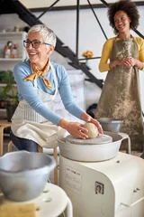 Senior woman making clay pot on pottery workshop .Creative, hobby ,activities concept © luckybusiness