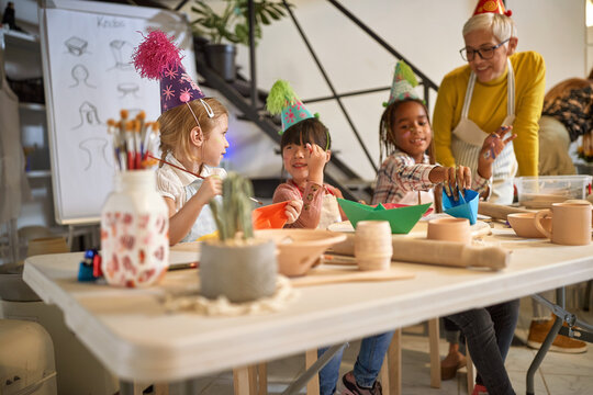 Smiling kids on creative workshop celebrate together a birthday.  Creative, hobby ,workshop  concept