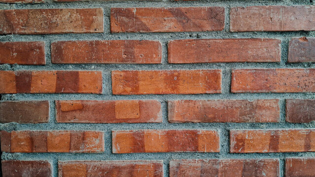 Exposed red clay brick wall close-up with distinctive blue-gray mortar &mdash; industrial rustic architecture texture background for interior design and editorial use.