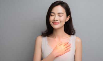 Obraz premium Young asian woman chest pain hand on chest gray background portrait studio shot pain expression health care medicine ache