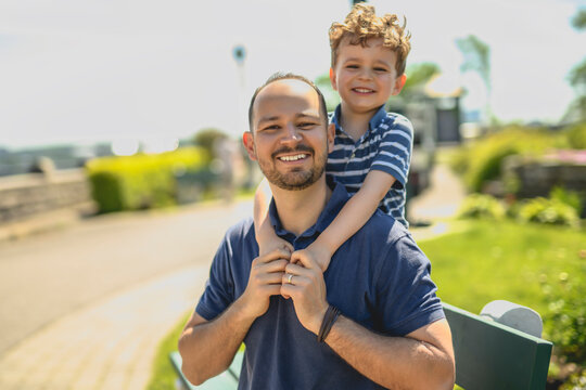 man playing with his son outdoors in park place
