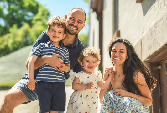 family of four people playing with childs outdoors in urban place