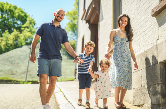 family of four people playing with childs outdoors in urban place