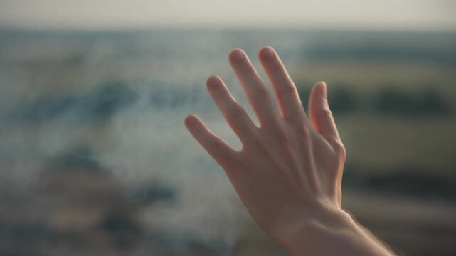 Dolly Shot Moving Slowly Past a Human Hand Gently Waving Away Faint Wisps of White Smoke, Cinematic Full HD Storytelling