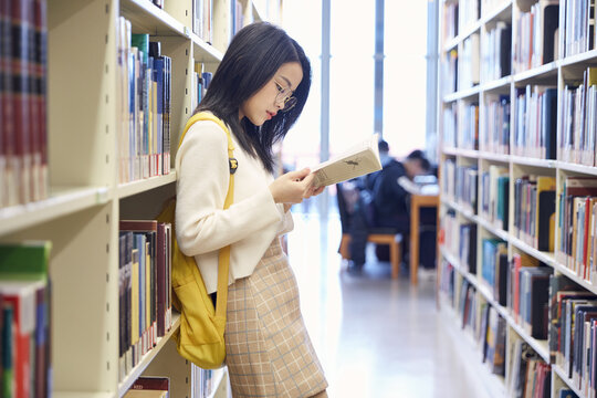 Female Student Reading Book in Library
