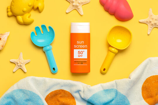 Top view of bottle of sunscreen 50+,beach toys and beach towel. Concept of sun protection