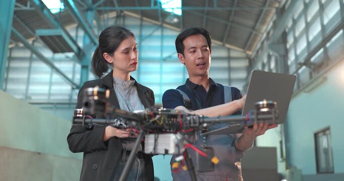Startup Entrepreneur and Engineer Review Drone Prototype in Industrial Workshop