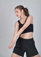 Obraz premium Sportliche junge Frau beim Dehnen in Trainingskleidung. Modernes Fitness-Porträt für Sport, Workout, Gesundheit, Beweglichkeit, Wellness und aktiven Lebensstil. Echtfoto. ballerina balette training 