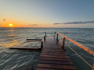 Fototapeta premium comfortable hammock on a wooden pier over the sea in sunset