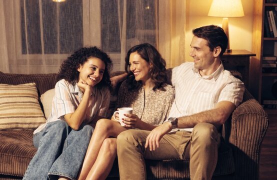 A happy family of three shares a warm moment together on the couch