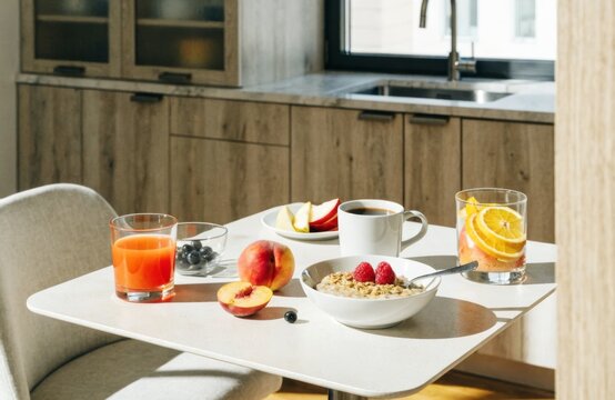 Healthy breakfast spread with oatmeal, fruit, coffee, and juice on a bright morning