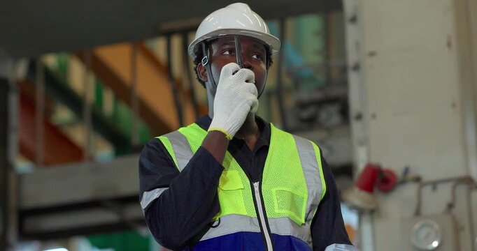 Factory supervisor directing production team with walkie-talkie