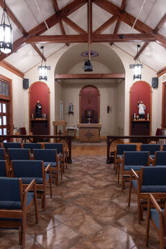 Small church with wooden pews and hanging lights