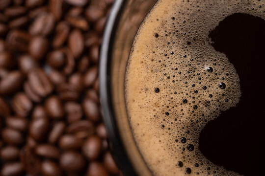 cup of coffee with beans. The top view of a coffee cup and group of black coffee beans is the background. Strong black espresso, Grounds of coffee background, texture.
