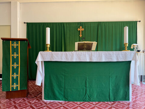 Church altar table with green paraments and candles