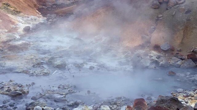 Boiling mud pots and hot springs steaming in the Seltun geothermal area. Volcanic landscape with sulfurous fumaroles in Krysuvik