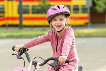 Obraz premium Happy child riding bicycle wearing safety helmet outdoors