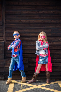 Children dressed as superheroes outdoors.