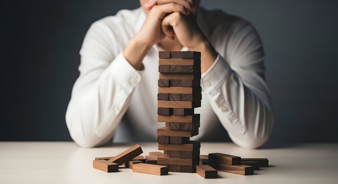 Unstable jenga tower with woman in background risk and failure concept