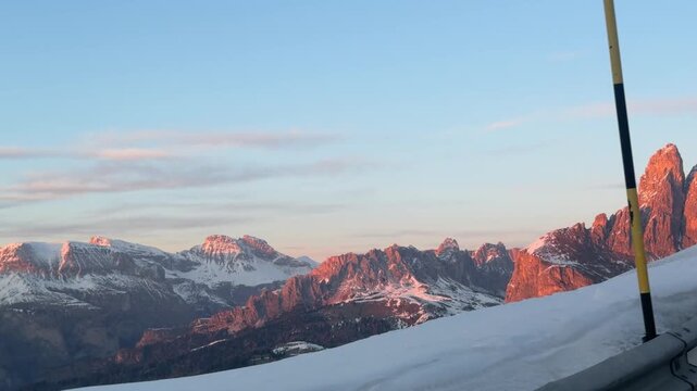 Driving through Selva di Val Gardena at sunset. The Dolomites glow with Enrosadira colors, creating one of the most beautiful alpine landscapes in Dolomiti Superski