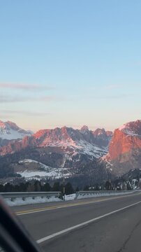Driving through Selva di Val Gardena at sunset. The Dolomites glow with Enrosadira colors, creating one of the most breathtaking winter views in Dolomiti Superski