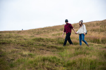 Naklejka premium Couple hiking grassy hill together