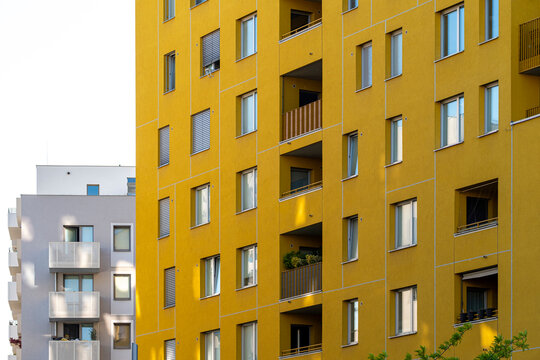 Yellow residential apartment facade fills Nordbahnviertel, Vienna, Austria, with repeating windows and balconies as urban architecture meets a narrow white edge