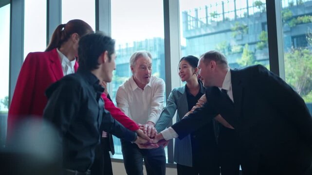 Business professionals stacking hands together to show teamwork	